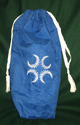 Bright blue linen bottle bag, embroidered with a 'laurel cross' in white thread